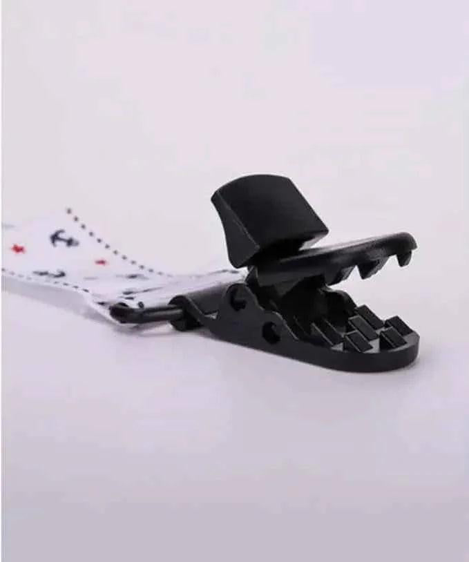 Close-up of a plastic clip with jagged teeth attached to a polka dot strap