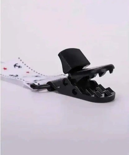 Close-up of a plastic clip with jagged teeth attached to a polka dot strap