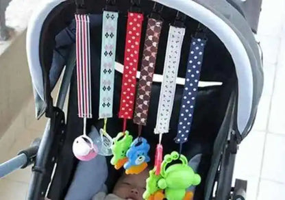 Colorful stroller hanging toys with animal designs above a sleeping baby.