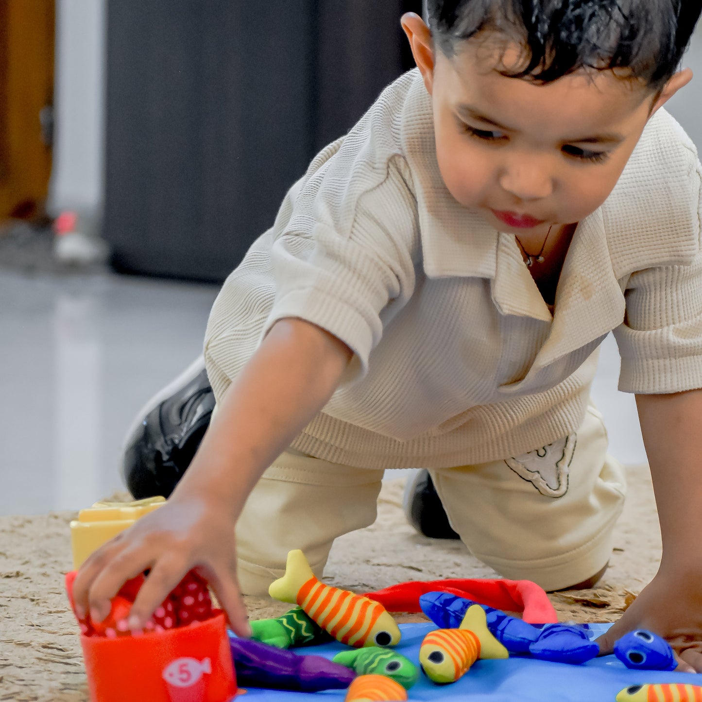 Toddler playing with colorful Montessori Fishing Game for Toddlers 1-3 by TurtleBee on carpet